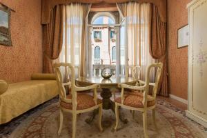 a dining room with a table and chairs and a window at Locanda Cà Le Vele in Venice
