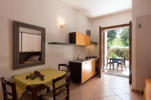 a kitchen and dining room with a table and a mirror at Residence Costa d’Otranto in Otranto