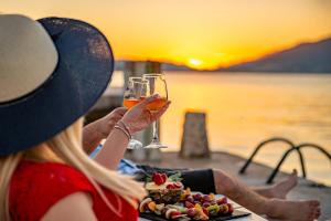 a woman sitting at a table with two glasses of wine at Apartments Dragojević in Tivat