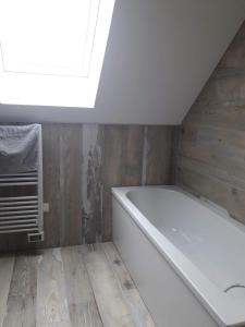 a white bath tub in a bathroom with a skylight at Le Chant des Vagues in Audinghen