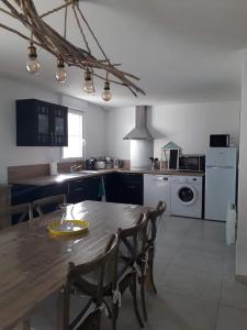 uma cozinha com uma mesa de madeira e cadeiras num quarto em Le Chant des Vagues em Audinghen