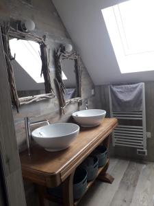 a bathroom with two sinks on a wooden table at Le Chant des Vagues in Audinghen