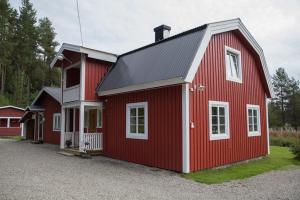 un granero rojo con adornos blancos en una casa en Kolbacken stugby & Camping en Åsarna