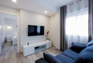 a living room with a blue couch and a tv at Palm Mar de LUX A32 in Palm-Mar