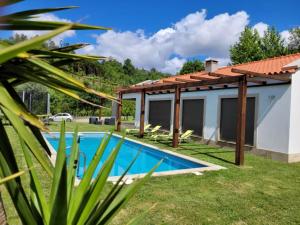 a backyard with a swimming pool and a house at Casa da Quinta do Sóto in Terras de Bouro