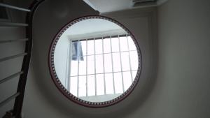a round mirror in a room with a window at Lammas Park House in Dawlish