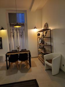 a living room with a table and chairs and a shelf at Ketia p in Marseille