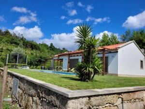 eine Villa mit Swimmingpool und ein Haus in der Unterkunft Casa da Quinta do Sóto in Terras de Bouro
