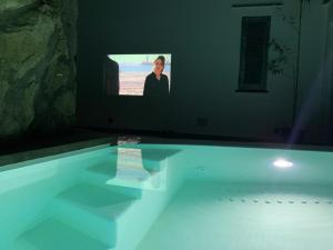 una TV seduta sopra una vasca da bagno di Rock House Villa a Ischia