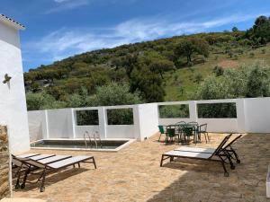 eine Terrasse mit einem Tisch, Stühlen und einem Pool in der Unterkunft Azeite de Marvão, Olivoturismo casa Venda do Lagar in Marvão