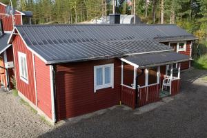 un pequeño edificio rojo con techo solar en Kolbacken stugby & Camping en Åsarna