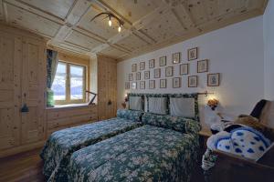 Schlafzimmer mit einem Bett mit grüner Tagesdecke in der Unterkunft Sur Puoz 13 - Samedan in Samedan