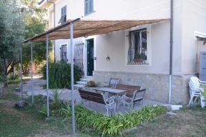 a patio with a bench and a table in front of a house at Calicantus bed and breakfast in Albenga