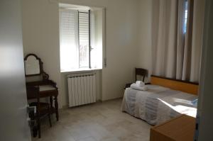 a bedroom with a bed and a desk and a window at Calicantus bed and breakfast in Albenga