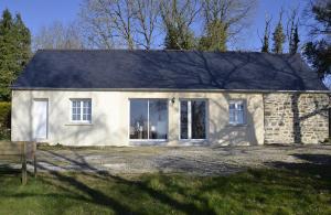 uma casa de pedra branca com uma grande janela em Couloumine breizh em Saint-Aignan