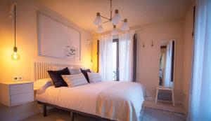 a bedroom with a white bed and a window at Apartamentos UXAMA LUXURY EPONA - junto a la Plaza Mayor con ascensor in El Burgo de Osma