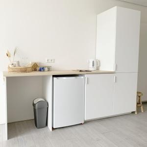 a white kitchen with a counter and a refrigerator at Sea you soon in Den Burg