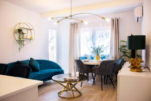 a living room with a blue couch and a table at Duerme junto a la Plaza de Toros de Granada. in Granada