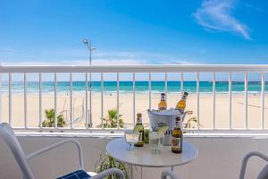 un tavolo con bottiglie e bicchieri su un balcone con vista sulla spiaggia di Mar de Fondo a Barbate
