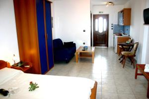a room with a bed and a living room at Studios Erotokritos in Ammouliani