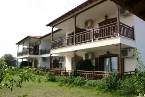 a large white building with balconies and a yard at Studios Erotokritos in Ammouliani