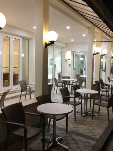 a restaurant with tables and chairs and windows at Hotel Linda in Caorle