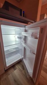 um frigorífico vazio com a porta aberta numa cozinha em ALES apartman em Sombor mais 37 fotografias
