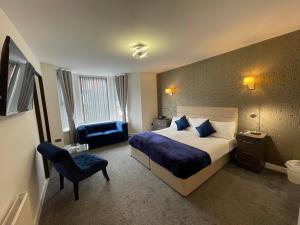 um quarto de hotel com uma cama e uma cadeira em Ruskin Hotel em Blackpool