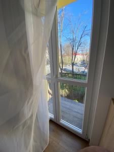 ventana con cortina y vistas al patio en Cozy apartment in the Business area of Bucharest en Bucarest