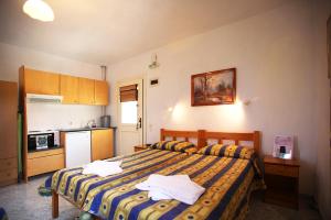 1 dormitorio con 1 cama y cocina pequeña en Alexandros Rooms & Studios, en Skopelos Town