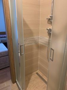 a shower with a glass door in a bathroom at Café de la Crème in Kuželov