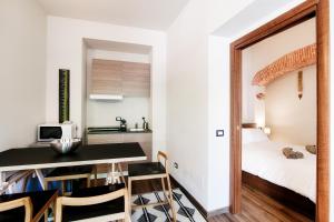 a small apartment with a bedroom and a table and chairs at Palazzo Del Pero - The House Of Travelers in Como +152 photos
