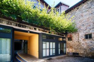 an entrance to a brick building with plants on top at Palazzo Del Pero - The House Of Travelers in Como
