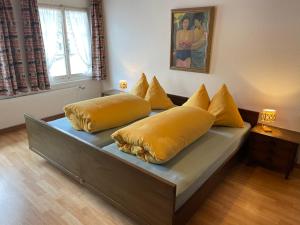 un letto con cuscini gialli sopra di Landgasthof Schäfle a Sankt Peterzell