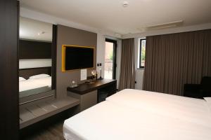 a hotel room with a bed and a television at Hotel Au Prince Royal in Leopoldsburg