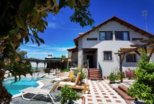 eine Villa mit einem Pool und einem Haus in der Unterkunft Rural villa Private pool, BBQ, court ,20' airport in Nea Kallikratia