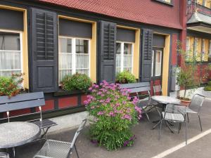 a group of tables and chairs outside a building with flowers at Landgasthof Schäfle in Sankt Peterzell