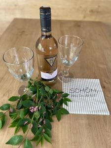 eine Flasche Wein und zwei Gläser auf einem Holztisch in der Unterkunft Apartment Kleine Kremper in Glückstadt