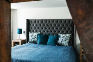a bedroom with a blue bed with a black headboard at Landhotel Bonsmann's Hof in Herdecke