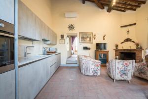 eine Küche mit 2 Stühlen und einem Kamin in der Unterkunft Casa ALTA in Greve in Chianti