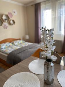 un jarrón de flores sobre una mesa en un dormitorio en Fortuna 8, en Hajdúszoboszló