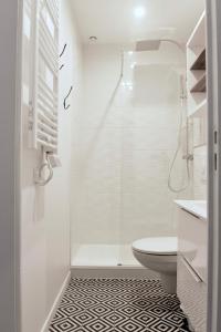 a white bathroom with a shower and a toilet at Duplex Bastié T3 calme et climatisé WiFi in Lyon