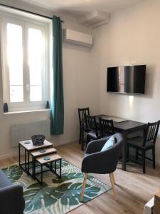 een woonkamer met een tafel en een eetkamer bij Duplex Bastié T3 calme et climatisé WiFi in Lyon