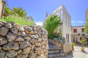 a stone wall in front of a house at Apartments Vitoria in Mali Lošinj