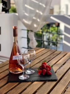 una bottiglia di vino e due bicchieri su un tavolo di legno di Villa Smaragdi-Despoina a Malona Village