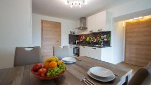 a kitchen with a wooden table with a bowl of fruit at Gästehaus Dobernig in Sankt Niklas an der Drau +11 photos
