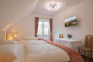a bedroom with a bed and a table in it at Gästehaus Dobernig in Sankt Niklas an der Drau