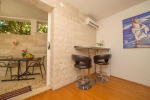 a room with a table and chairs and a painting at Apartments Vitoria in Mali Lošinj
