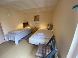 ein kleines Zimmer mit 2 Betten und einem Stuhl in der Unterkunft Margretelyst Ferielejlighed in Farsø