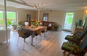 sala de estar con mesa y sillas en Margretelyst Ferielejlighed en Farsø